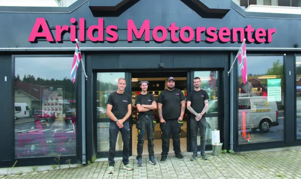 Ansatte hos Arilds motorsenter stående utenfor inngangen