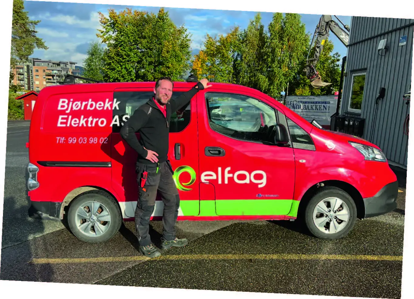 Rød Bjørbekk elektro bil med ansatt stående foran.